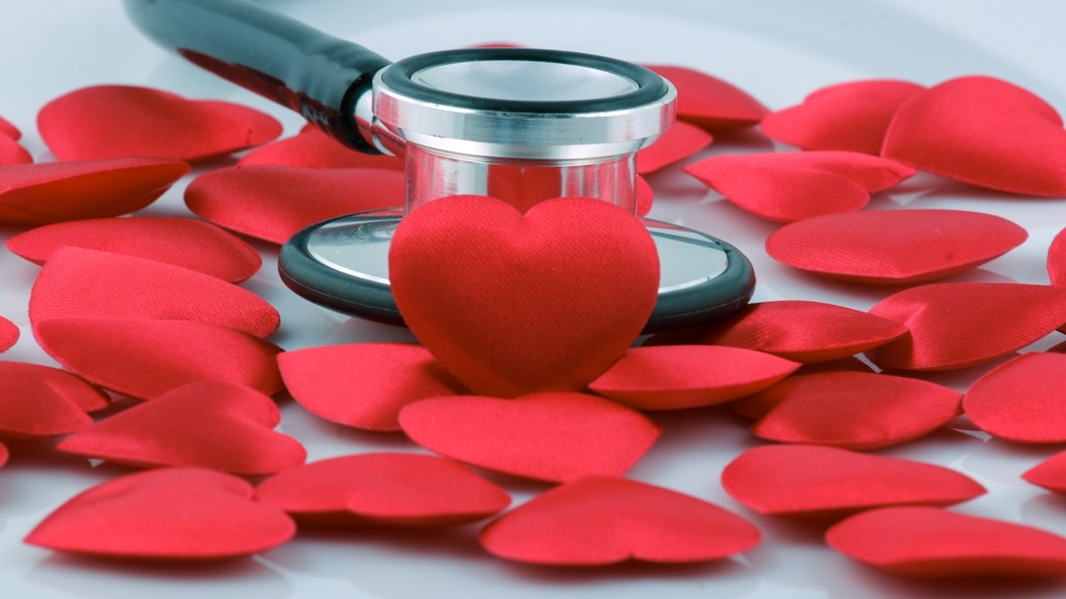 a stethoscope on top of a pile of red hearts